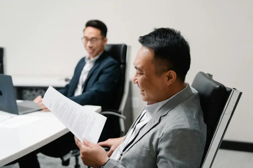 Hombre revisando documentos legales junto a un asesor durante el proceso de dación en pago de hipoteca.”